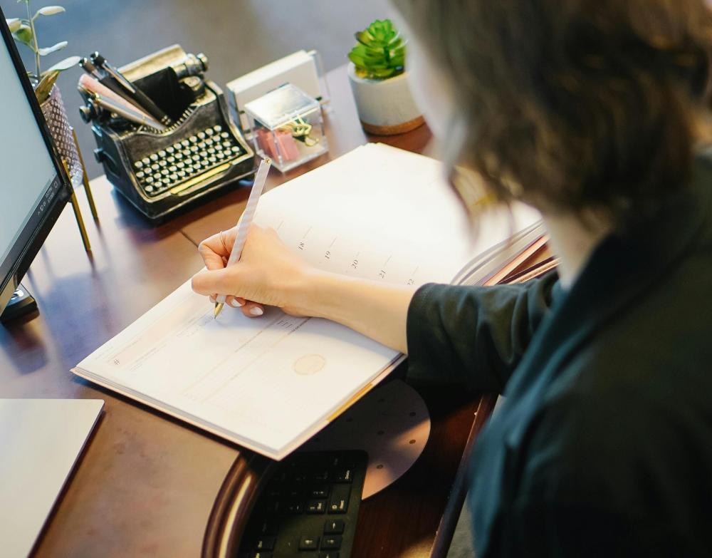 Person taking notes in front of their computer